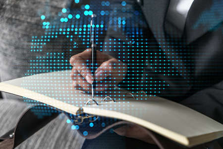 Planet earth map hologram and a woman taking notes. International network concept. Multiexposure.の写真素材