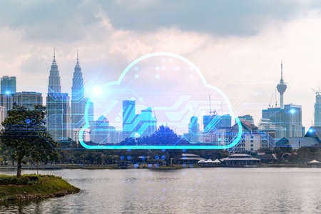 Glowing hologram of cloud icon, aerial panoramic cityscape of Kuala Lumpur at sunset. The concept of secure storage of digital data in KL, in Malaysia, Asia. Multi exposure.の写真素材