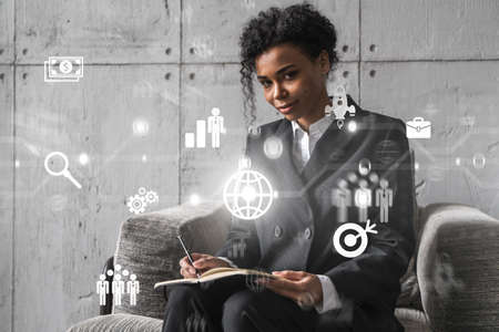 Businesswoman typing on laptop work in modern office on new project. Business icon drawing hologram. Double exposure. Concept of success.の写真素材