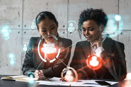 Two businesswomen work together in modern office on new project. Double exposure. Concept of...