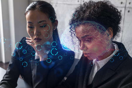 Two businesswomen work together in modern office on new project. Double exposure. Concept of...