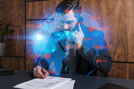 A man in office signing papers while talking mobile and planet earth hologram. Double exposure. Formal wear.の写真素材