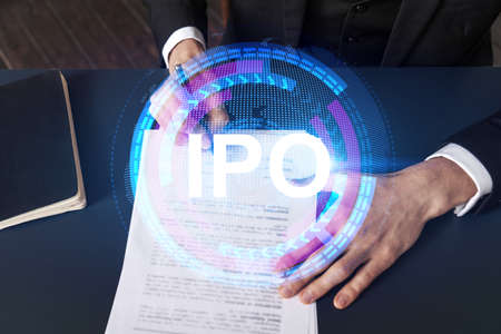 Businessman in suit signs paper. Double exposure with IPO icon hologram. Man signing contract agreement. Primary stock issue market analysis and investment concept.の写真素材