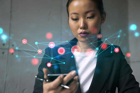 Businesswoman using phone, work in modern office on new project. Double exposure. Concept of success. Abstract technology hologram.の写真素材