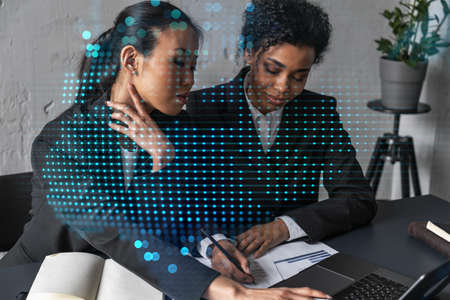 Two businesswomen work together in modern office on new project. Double exposure. Concept of success. Planet earth world map.の写真素材