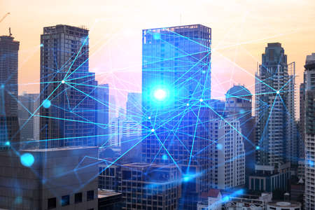 Hologram of abstract technology glowing icons, panoramic cityscape of Bangkok at sunset, Asia. The...