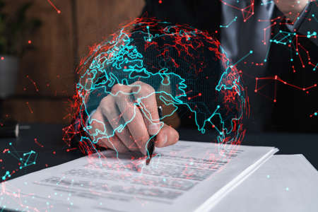 Businessman in suit signs contract. Double exposure with world map hologram. Man signing agreement...