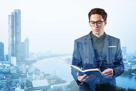 Young handsome businessman in suit and glasses thinking how to tackle the problem, new career...