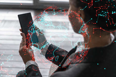 Businesswoman using phone, work in modern office on new project. Double exposure. Concept of success. World map planet earth hologram.の写真素材