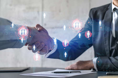 Multi exposure of two businesspeople handshake and world map hologram drawing background. Concept of...