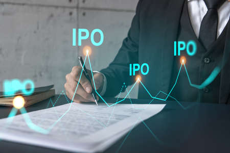 Businessman in suit signs paper. Double exposure with IPO icon hologram. Man signing contract...