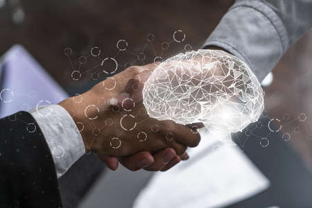 Multiexposure of two businesspeople handshake and brain hologram drawing background. Concept of data analysis. Formal wear.の写真素材