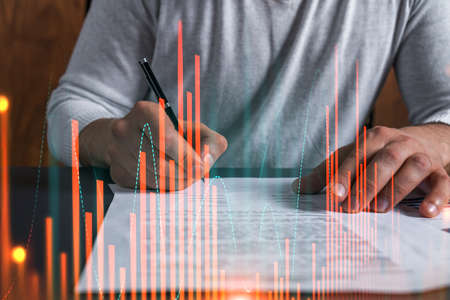 Double exposure of man signing contract and forex graph hologram. Blue infographic business chart. Concept of market investment.の写真素材