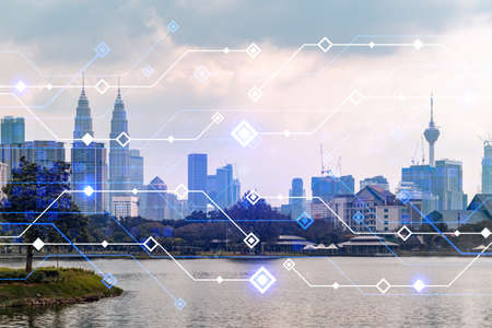 Glowing hologram of technological process, aerial panoramic cityscape of Kuala Lumpur at sunset. KL is the largest innovative hub of tech services in Malaysia, Asia. Multi exposure.の写真素材