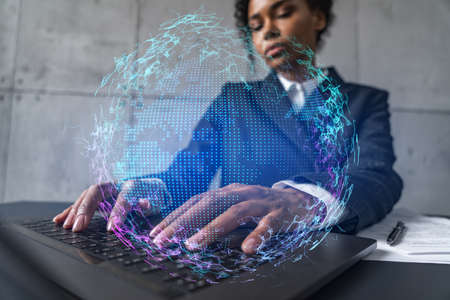 Businesswoman typing on laptop work in modern office on new project. World map drawing hologram. Double exposure. Concept of success.の写真素材