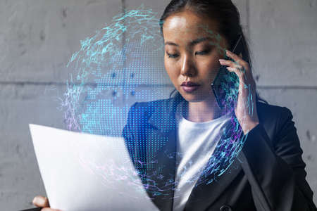 Businesswoman speaks phone and world map hologram. Double exposure.の写真素材