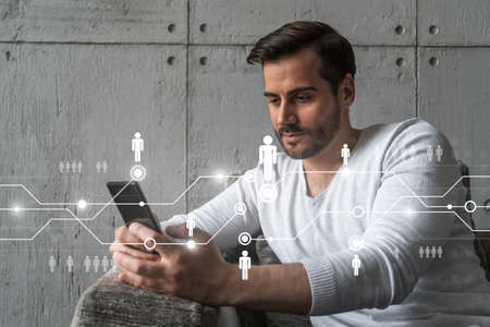 A man typing mobile phone. Double exposure. Social network theme drawing hologram. International people connection via internet information concept.の写真素材