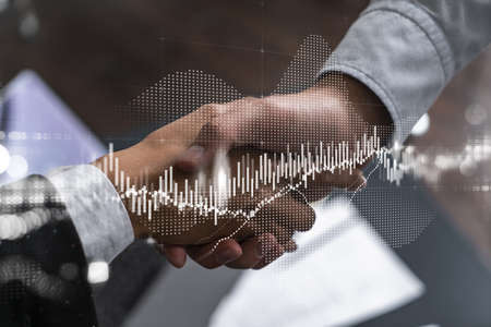 Double exposure of two businesspeople handshake and forex chart hologram drawing background. Concept of capital market analysis. Formal wear.の写真素材