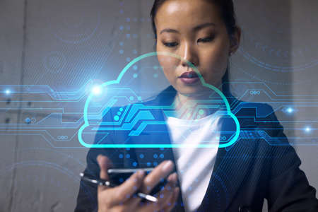 Businesswoman typing phone, work in modern office on new project. Cloud hologram. Double exposure. Concept of success.の写真素材