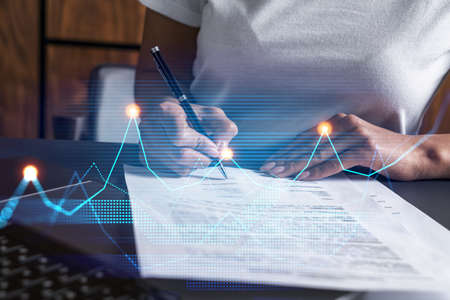 Woman signs agreement. Financial market chart and graph hologram. Double exposure . Business...