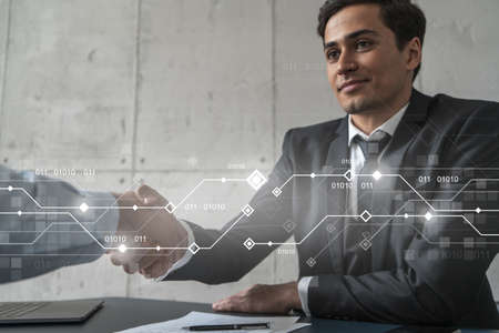 Two businessman shaking hands and technology theme hologram. Double exposure. Concept of...