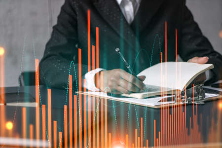 Financial stock market graph hologram and a woman taking notes. Business education and analysis...