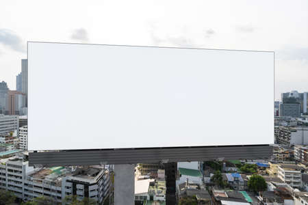Blank white road billboard with Bangkok cityscape background at day time. Street advertising poster, mock up, 3D rendering. Front view. The concept of marketing communication to promote or sell idea.の写真素材