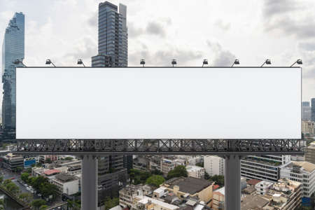 Blank white road billboard with Bangkok cityscape background at day time. Street advertising poster, mock up, 3D rendering. Front view. The concept of marketing communication to promote or sell idea.の写真素材