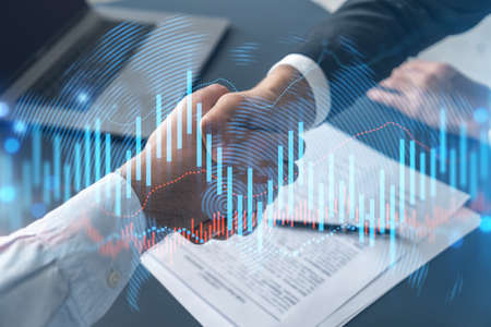 Multiexposure of two businesspeople handshake and forex graph hologram drawing background. Concept...