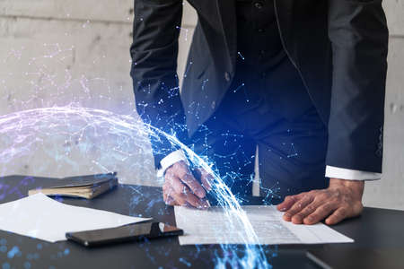 Businessman in suit signs contract. Double exposure with abstract technology hologram. Man signing...