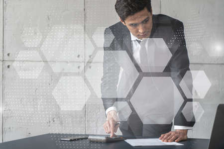 Businessman in office signs contract and abstract technology hologram. Double exposure. Formal wear.の写真素材