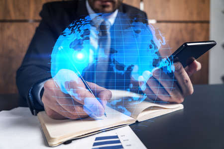 Man office takes notes use phone map world concept. Double exposure.の写真素材