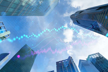 FOREX and stock market chart hologram on low, wide angle view of glass and steel contemporary skyscrapers in financial downtown. The concept of international trading. Double exposure.の写真素材