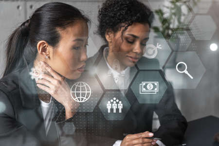 Two businesswomen work together in modern office on new project. Double exposure. Concept of success.の写真素材