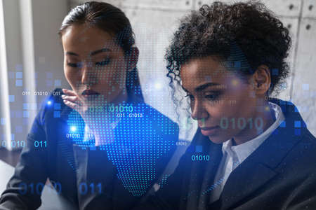 Two businesswomen work together in modern office on new project. Double exposure. Concept of success. Planet earth world map.の写真素材
