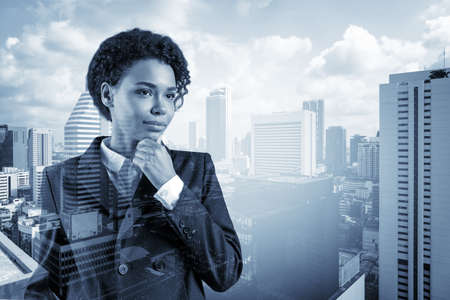 Attractive black African American business woman in suit with hand on chin thinking how to succeed,...