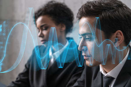 Two businesspeople working on market behavior. Trading concept. Financial graph hologram. Multiexposure.の写真素材