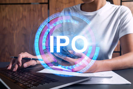 Businesswoman typing on computer in office. IPO icon hologram. Double exposure.の写真素材