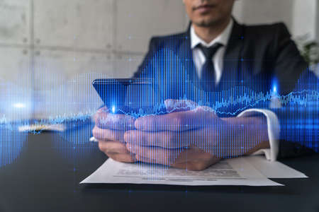 Trader in office working with Smartphone, FOREX graph hologram to analyze market behavior, typing phone. Double exposure.の写真素材