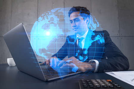 Businessman in office working with laptop, world map planet earth hologram, typing computer. Double exposure.の写真素材