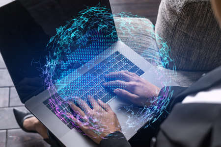 Businesswoman typing on laptop in office. Planet earth world map hologram. International business...