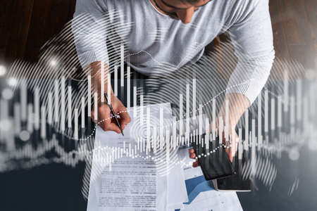 Good looking man working on investment project. Multiexposure. Forex graph Hologram.