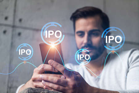 A man using smart phone. Double exposure. IPO symbol hologram. Initail primary offering concept.
