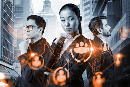 Group of SMM specialists working on social media marketing strategy to achieve business goals. Hologram icons over Singapore background.の写真素材