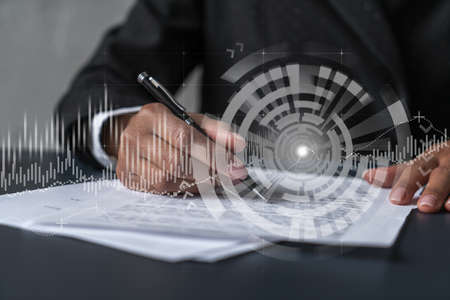 Woman signs agreement. Financial market chart and graph hologram. Double exposure . Business Analysis concept.の写真素材