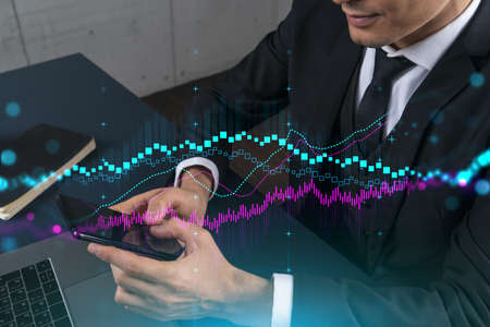 Trader in office working with Smartphone, FOREX graph hologram to analyze market behavior, typing...