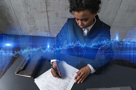 A woman signs contract and forex chart hologram. Concept of stock market analysis. Multiexposure. International business.の写真素材