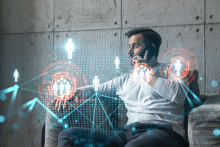 A man in casual wears, talking phone. Double exposure. Social network icons drawings hologram. People internet connection concept.の写真素材