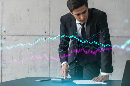 Businessman signs contract and financial chart hologram. Double exposure. Formal wear. Concept of...