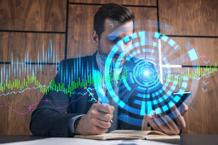 A businessman in office taking notes using phone and stock graph hologram. Multiexposure. Formal wear.の写真素材